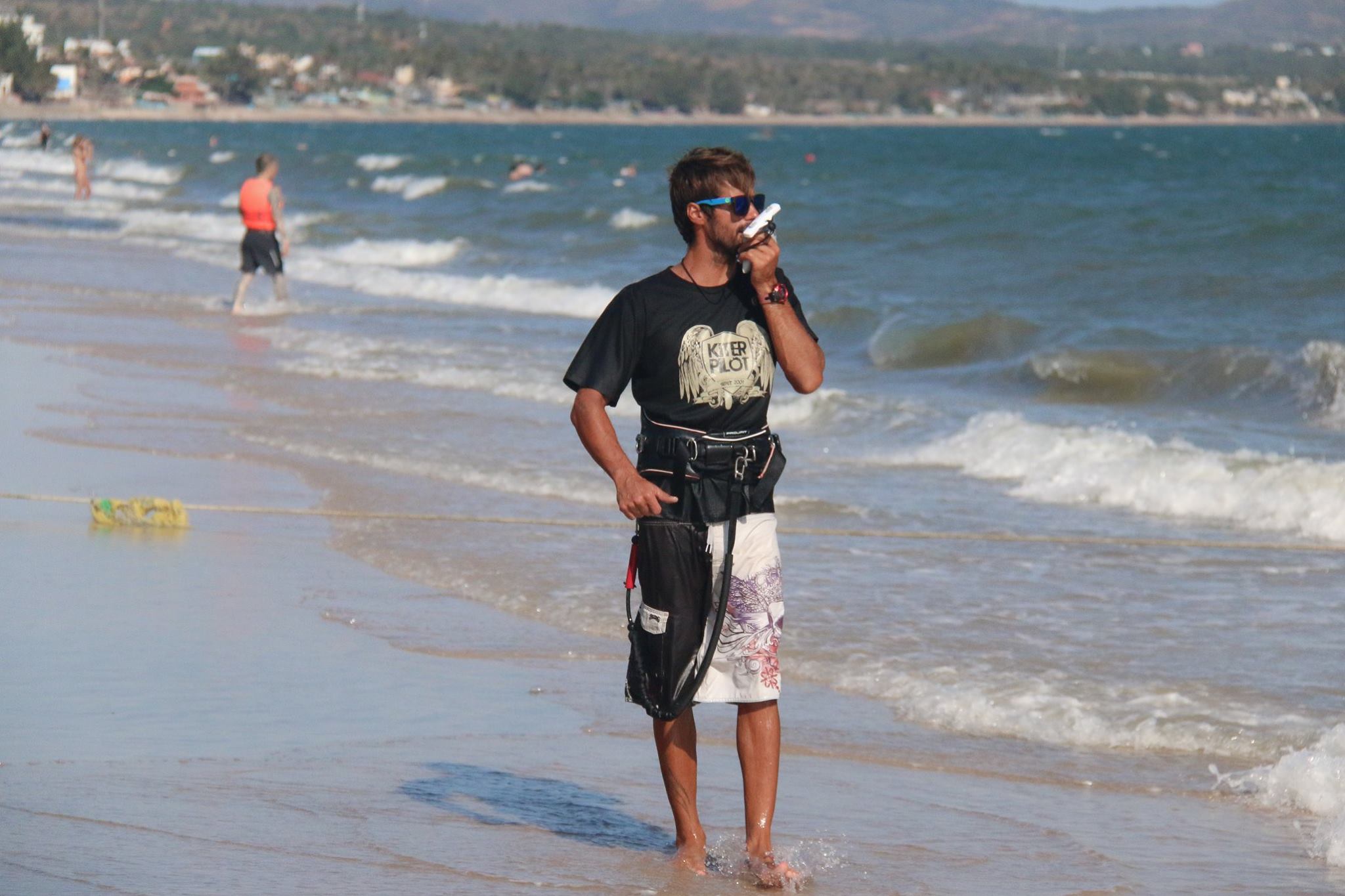 Viktor teaching on a beach with waves behind him